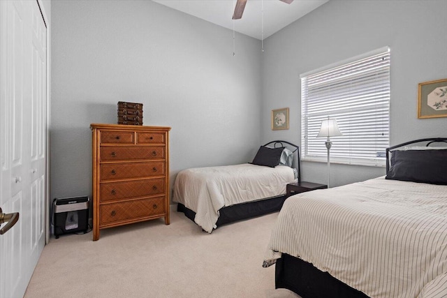 bedroom featuring light colored carpet, a closet, and ceiling fan