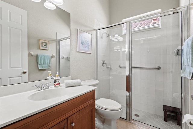 bathroom with tile patterned flooring, vanity, toilet, and walk in shower