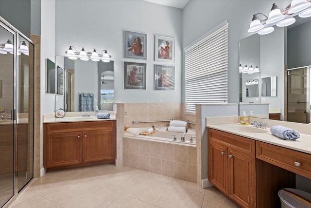 bathroom featuring shower with separate bathtub, vanity, and tile patterned floors