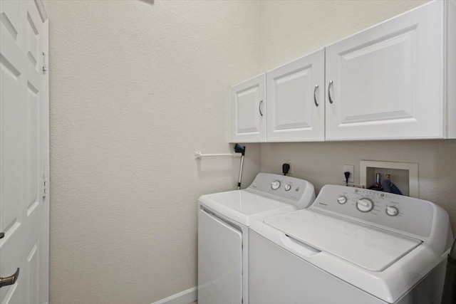 washroom with washing machine and dryer and cabinets