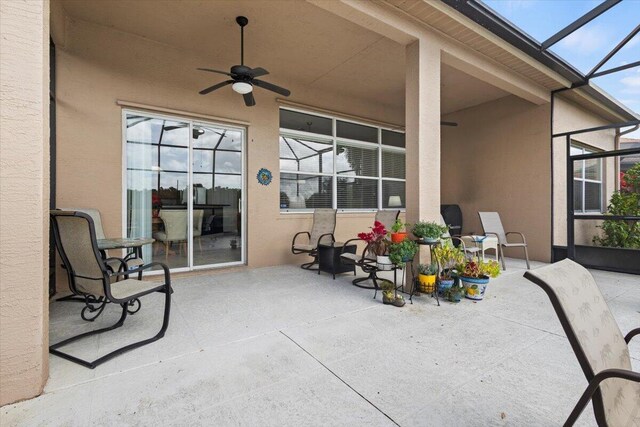 view of patio / terrace featuring glass enclosure and ceiling fan