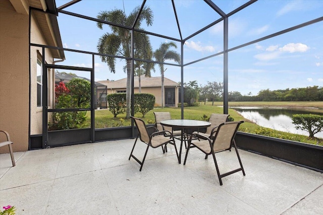 sunroom featuring a water view