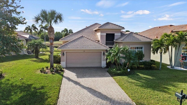 mediterranean / spanish-style house with a garage and a front lawn