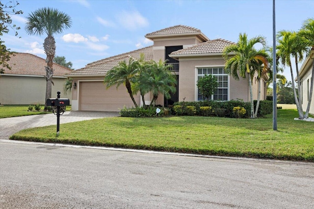 mediterranean / spanish home featuring a front yard and a garage