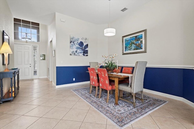 tiled dining area featuring a towering ceiling