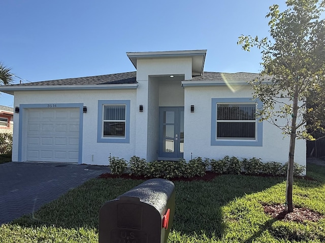 view of front of home with a garage and a front lawn