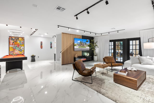 living room featuring french doors, pool table, and a chandelier