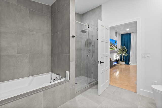 bathroom featuring tile patterned floors, independent shower and bath, and toilet