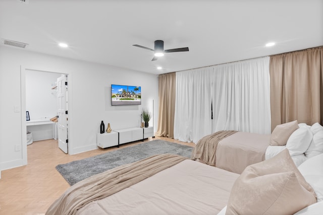 bedroom with light parquet floors, ensuite bathroom, and ceiling fan