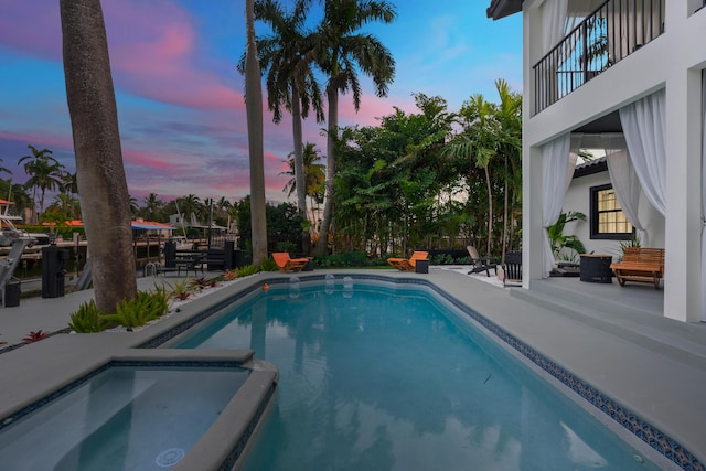 pool at dusk featuring a patio area