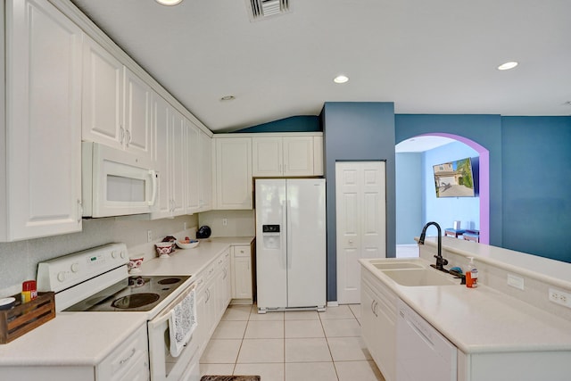 kitchen featuring white cabinetry, sink, vaulted ceiling, white appliances, and light tile patterned flooring