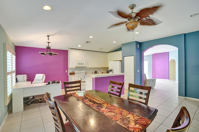 dining space featuring ceiling fan, light tile patterned floors, and vaulted ceiling