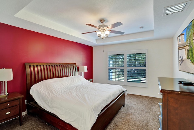 bedroom featuring a tray ceiling, ceiling fan, and carpet flooring