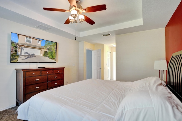 bedroom featuring carpet flooring, ceiling fan, and a raised ceiling