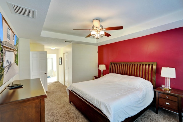 bedroom featuring carpet flooring, a raised ceiling, and ceiling fan