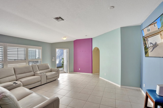 tiled living room featuring a textured ceiling