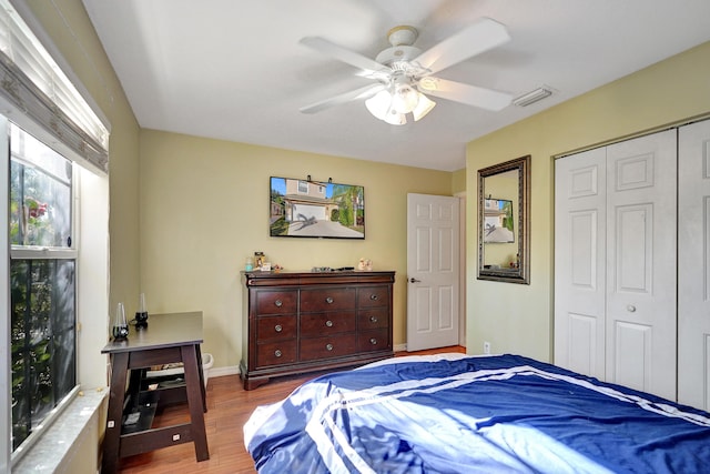 bedroom with ceiling fan, light hardwood / wood-style floors, and a closet