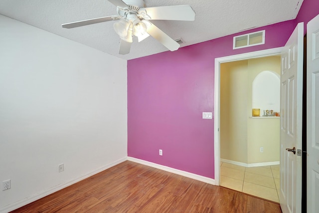 spare room with wood-type flooring, a textured ceiling, and ceiling fan