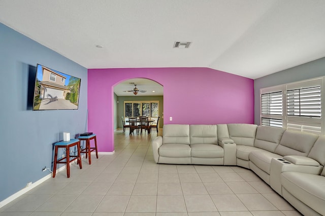 tiled living room featuring ceiling fan and vaulted ceiling