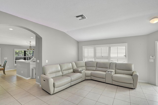 tiled living room featuring a textured ceiling and vaulted ceiling