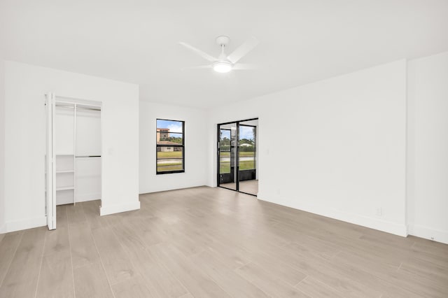 unfurnished bedroom featuring ceiling fan, access to exterior, and light hardwood / wood-style flooring