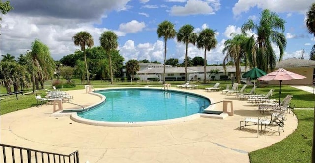 view of pool with a patio area and a lawn