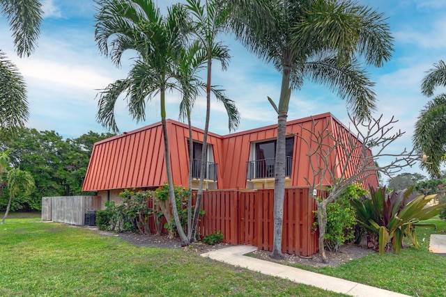 view of property exterior with a yard and central AC