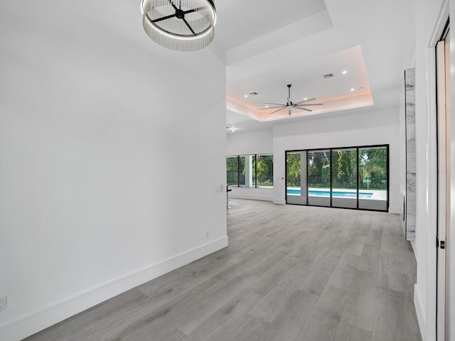 interior space featuring a raised ceiling and light wood-type flooring