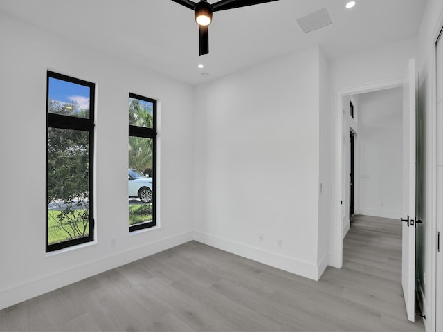 empty room with ceiling fan and light wood-type flooring