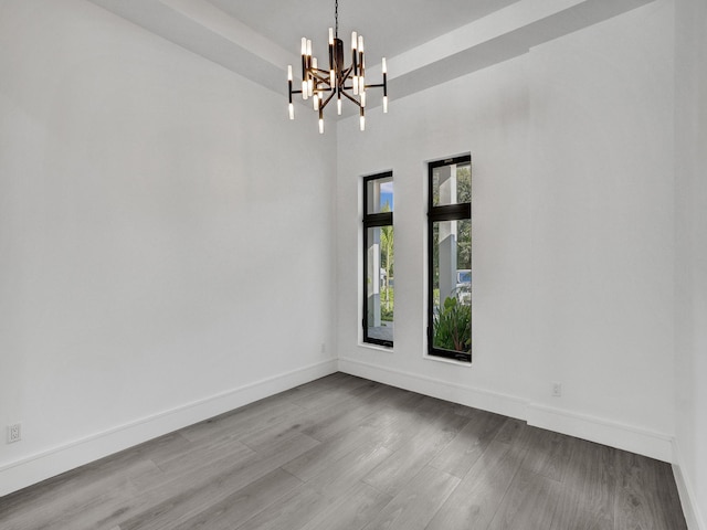 empty room featuring light hardwood / wood-style floors and a chandelier