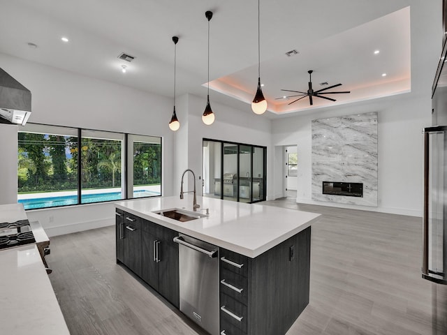 kitchen with dishwasher, sink, decorative light fixtures, ceiling fan, and a large island