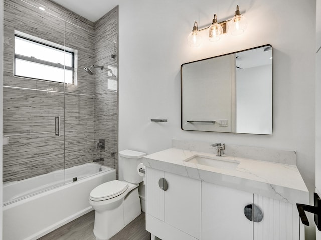 full bathroom featuring enclosed tub / shower combo, vanity, wood-type flooring, and toilet