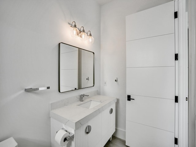 bathroom featuring hardwood / wood-style floors, vanity, and toilet