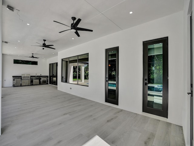 exterior space with ceiling fan and light hardwood / wood-style flooring