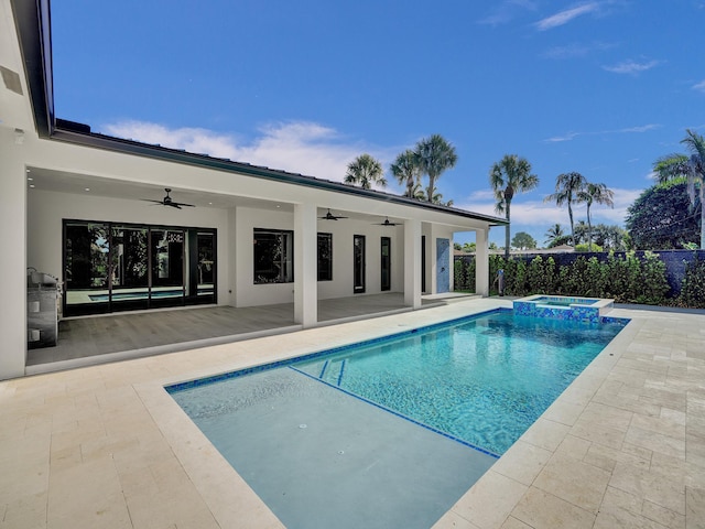 view of swimming pool with ceiling fan, an in ground hot tub, and a patio