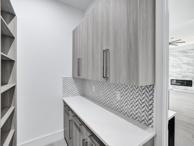 interior space with backsplash, hardwood / wood-style flooring, and ceiling fan