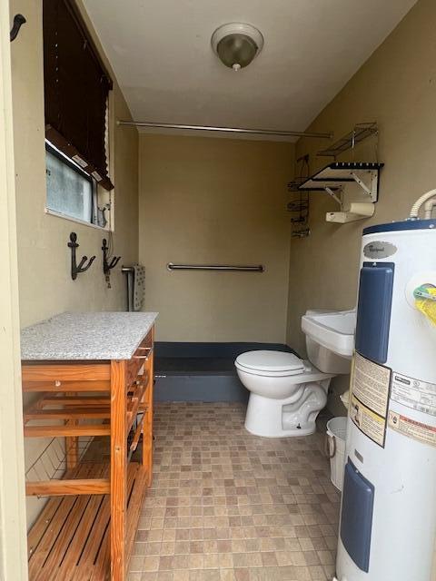 bathroom with electric water heater and toilet