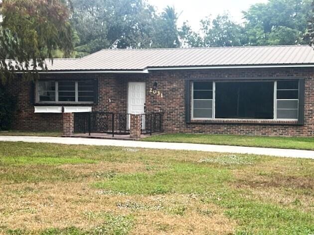 ranch-style home featuring a front lawn