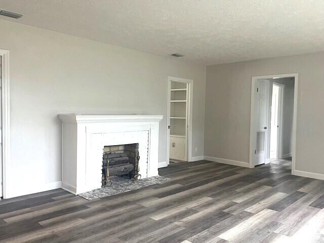 unfurnished living room with dark hardwood / wood-style floors and a textured ceiling