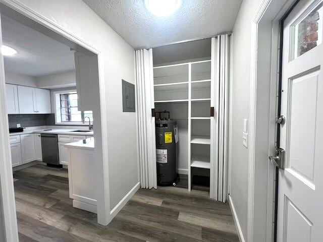 corridor with dark hardwood / wood-style floors, sink, a textured ceiling, and water heater