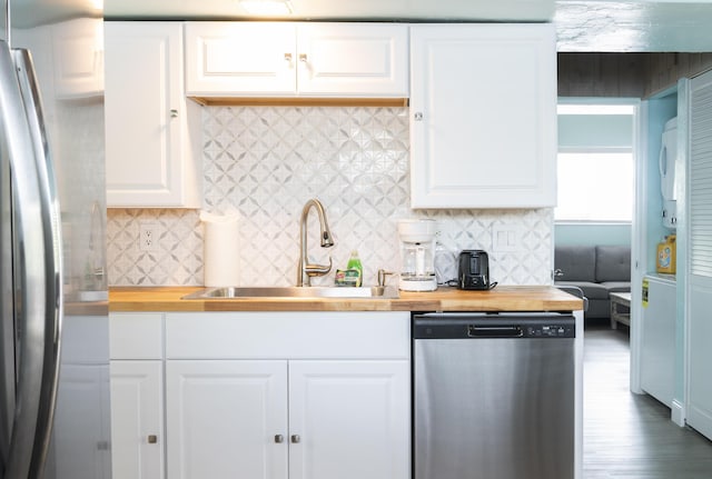 kitchen featuring wooden counters, sink, appliances with stainless steel finishes, tasteful backsplash, and white cabinetry