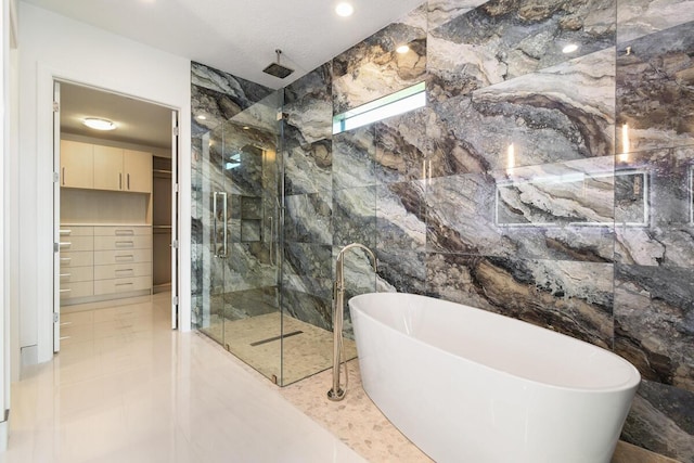 bathroom with shower with separate bathtub, tile patterned floors, and tile walls