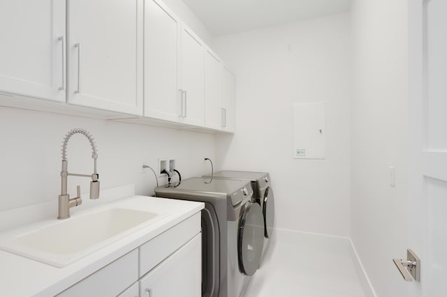 laundry room with washer and clothes dryer, sink, and cabinets