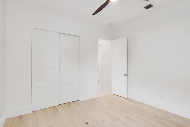 unfurnished bedroom with ceiling fan, a closet, and light hardwood / wood-style flooring