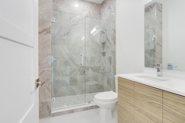 bathroom with walk in shower, vanity, and toilet