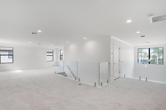 empty room featuring light colored carpet and crown molding