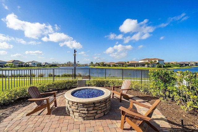 view of patio with a water view and an outdoor fire pit