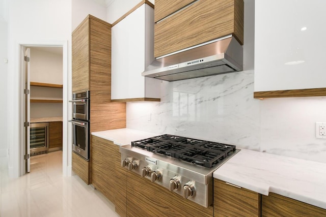 kitchen featuring decorative backsplash, wall chimney range hood, appliances with stainless steel finishes, and beverage cooler