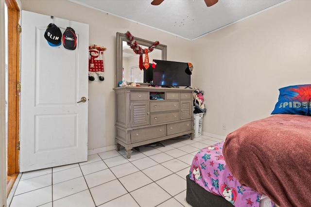 bedroom with light tile patterned floors, baseboards, a textured ceiling, and a ceiling fan