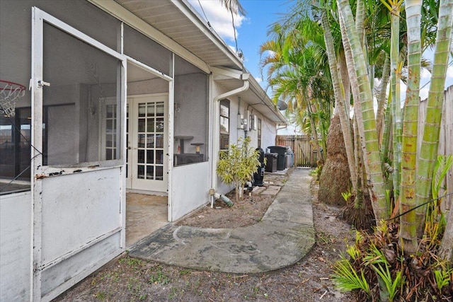 view of property exterior with stucco siding and fence